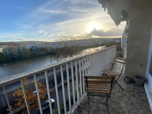 d'un balcon avec une chaise et une vue sur la rivière. dans l'établissement Appartement sur quai de Seine, à Boulogne-Billancourt