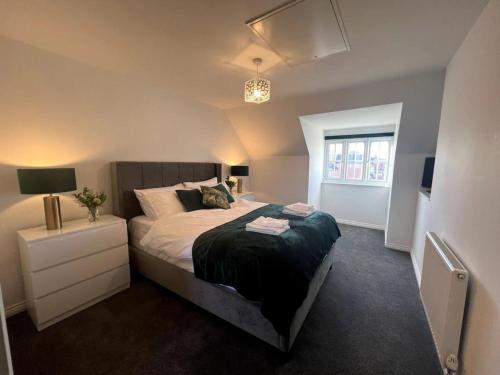 a bedroom with a large bed and a window at Pass the Keys 3 Bed home away from home in Colchester