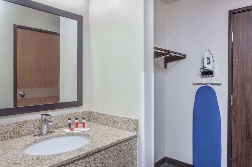 a bathroom with a sink and a mirror at Days Inn & Suites by Wyndham East Flagstaff in Flagstaff