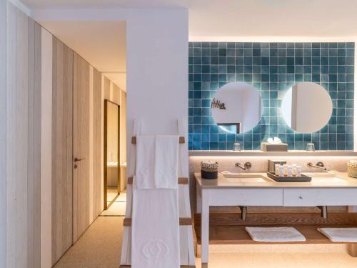 a bathroom with a sink and two mirrors at Sofitel Agadir Thalassa Sea & Spa in Agadir