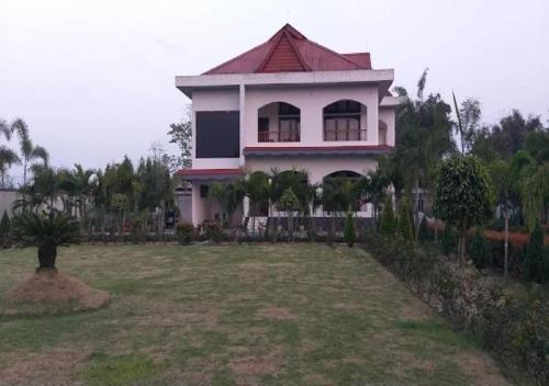 una casa blanca con techo rojo en un patio en Chet Residency Namsai, en Namsai