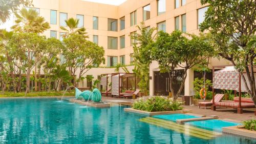 a swimming pool in front of a building at Hyatt Pune in Pune