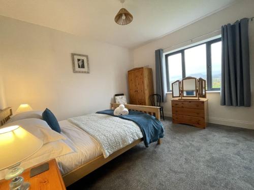 1 dormitorio con cama y ventana grande en Langrigg Cottage en Portinscale
