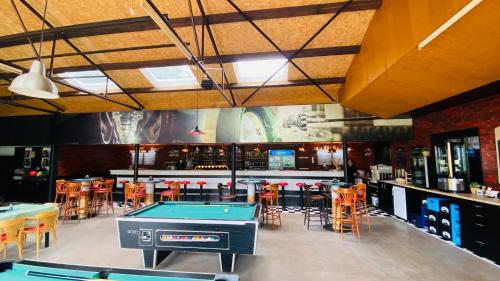 un bar con tavolo da ping pong e sedie di Chatový areál Zděřina a Police nad Metují