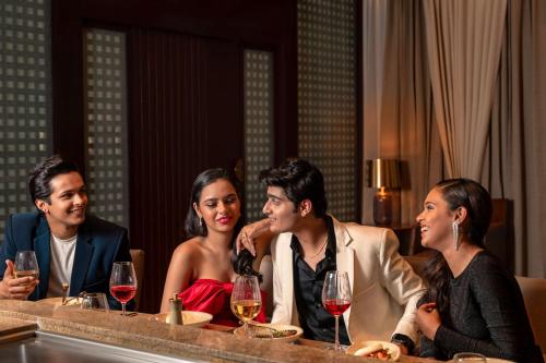 a group of people sitting at a table with wine glasses at Hyatt Pune in Pune