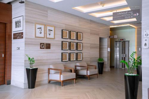 een wachtkamer met stoelen en foto's aan de muur bij Hilton Garden Inn Dubai Al Muraqabat - Deira in Dubai