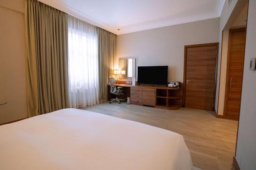 a hotel room with a bed and a television at Hilton Garden Inn Dubai Deira in Dubai