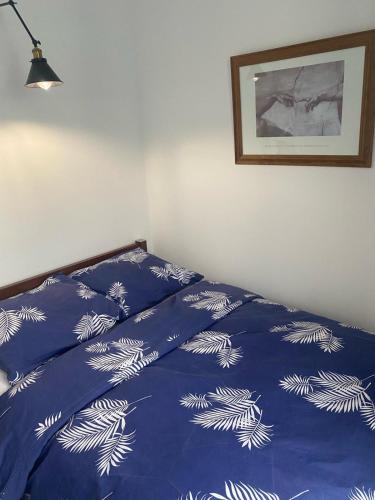 a bed in a bedroom with a blue comforter with dandelions at Klonowa 65 z garażem podziemnym in Kielce