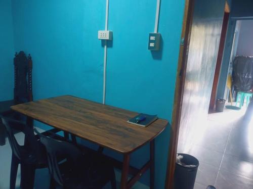 a wooden table in a room with a blue wall at Couple room blue RODEWAY HOUSE SPACE RENTAL in Pico