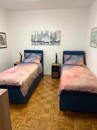 a bedroom with two beds and a wooden floor at Apartmani Selce in Selce