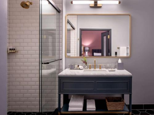 een badkamer met een wastafel en een spiegel bij The Eliza Jane, in The Unbound Collection by Hyatt in New Orleans
