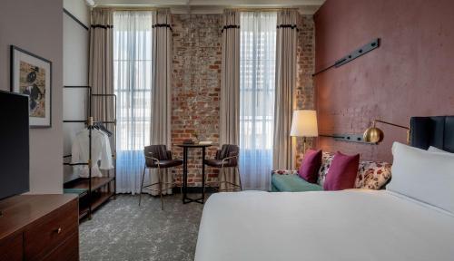 Pokój hotelowy z białym łóżkiem i ceglaną ścianą w obiekcie The Eliza Jane, in The Unbound Collection by Hyatt w Nowym Orleanie