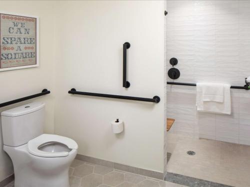 a bathroom with a white toilet and a shower at Canopy By Hilton Charlotte SouthPark in Charlotte