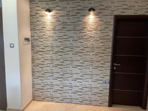 a brick wall with lights next to a door at Guest house GN in Naousa Imathias