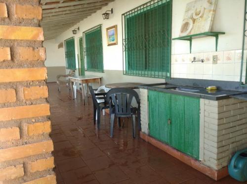 Recanto da Vandeka as margens do Rio Grande في باسوس: مطبخ مع كراسي وطاولة في مبنى