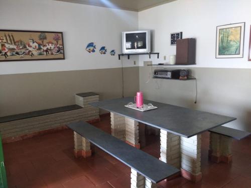 einen Tisch und eine Bank in einem Zimmer in der Unterkunft Recanto da Vandeka as margens do Rio Grande in Passos