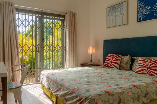 a bedroom with a bed and a large window at Stunning Belle Mare Beachfront luxury Apartment in Belle Mare