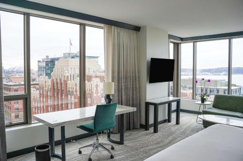 a hotel room with a bed and a desk and windows at Hotel 1000, LXR Hotels & Resorts in Seattle