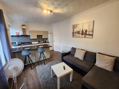 a living room with a couch and a kitchen at Double King Bed Central Apartment by Property Promise in Cardiff