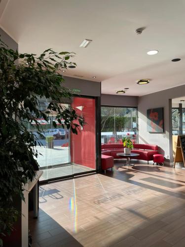 a lobby with red couches in a building at Ibis Girona in Girona
