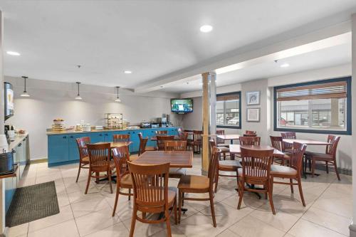 un comedor con mesas y sillas en un restaurante en Country Inn & Suites by Radisson, Saskatoon, SK, en Saskatoon