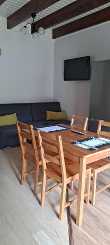 a dining room table with two chairs and a couch at Apartamenty Nad Stawem in Powidz