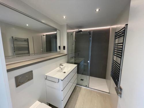 a bathroom with a white sink and a shower at Deluxe Marina View Seafront Gibraltar Stay in Gibraltar