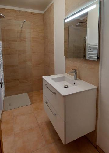une salle de bain avec un lavabo blanc et un miroir dans l'établissement Grand T3 Lumineux Spacieux Propre, tout confort, Parking, Ascenseur, Emplacement central unique, port-commerces-mer et plages à pied, Location du Samedi au Samedi, à Sanary-sur-Mer