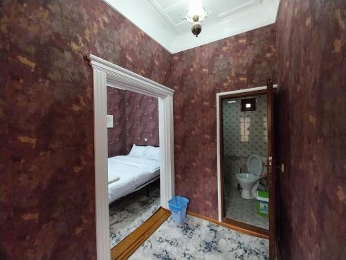Habitación pequeña con cama y espejo. en Fayz Guest House, en Samarkand