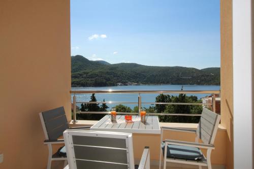 a balcony with a table and chairs and a view of the water at Slano Bay Apartments in Slano