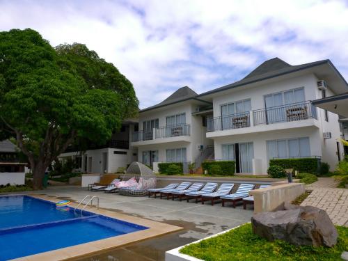 ein Gebäude mit einem Pool und einem Haus in der Unterkunft Hava Resort Calatagan 