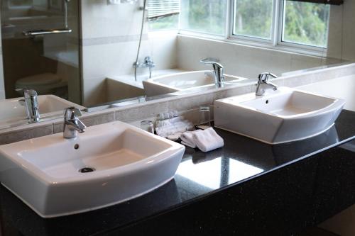 金馬崙高原的住宿－金馬崙高原遺物酒店，一间带两个盥洗盆和大镜子的浴室