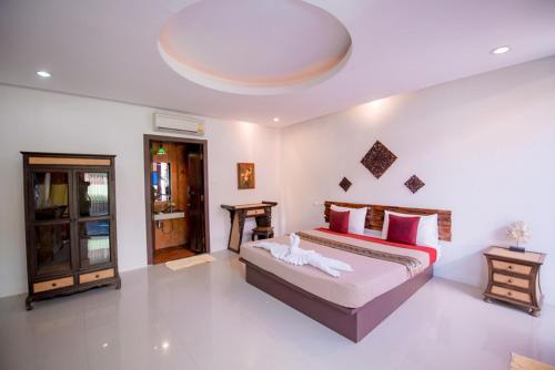 Pool villa 2 bedroom في بران بوري: غرفة نوم بسرير كبير ومخدات حمراء