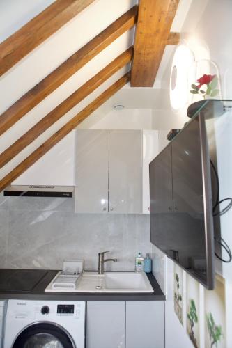 une cuisine avec un évier et une machine à laver dans l'établissement EIFFEL TOWER - Passy, à Paris