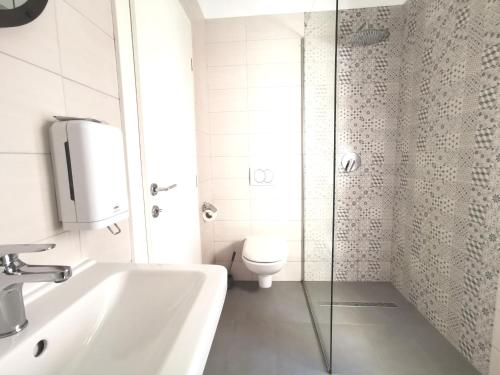 Baño blanco con lavabo y aseo en A&M Apartment and Rooms, en Split