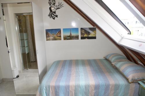 - un lit dans une chambre avec 3 photos sur le mur dans l'établissement EIFFEL TOWER - Passy, à Paris