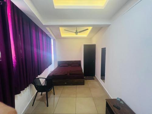 a bedroom with a bed and a ceiling with purple curtains at AROMA INN in Kalpetta