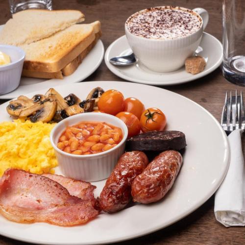 a plate of breakfast food with eggs sausage and beans at Derby Arms Witherslack in Grange Over Sands