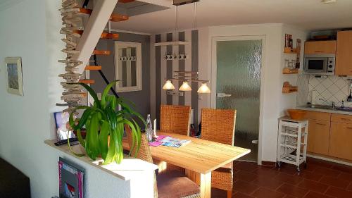 a dining room with a wooden table and chairs at Ferienhaus Ostseebrise Usedom im Grünen familienfreundlich ruhig Parkplatz Terrasse Kamin in Ostseebad Karlshagen