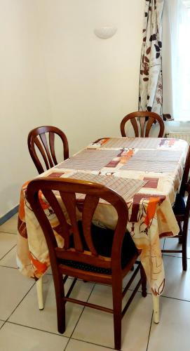a wooden table with two chairs and a table cloth at Belle chambre dans un quartier calme in Brussels