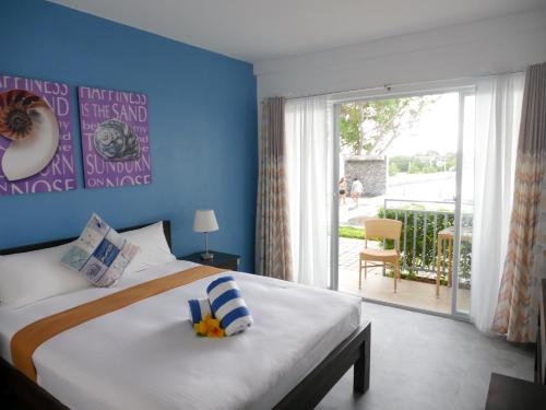 Schlafzimmer mit einem Bett mit blauer Wand in der Unterkunft Hava Resort Calatagan 