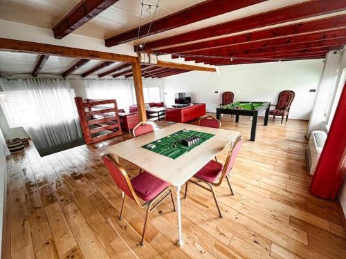 a room with a table and some chairs and a room with a table at Villa avec piscine intérieure in Holtzheim