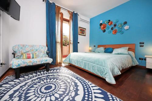 a bedroom with blue walls and a bed and a chair at Alla fiera di Roma in Ponte Galeria