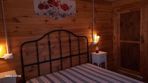 a bedroom with a bed in a wooden cabin at Podere Oliveta in Montecatini Val di Cecina