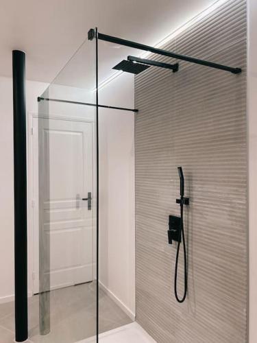um chuveiro com uma porta de vidro na casa de banho em Cosy love room em Le Plessis-Belleville