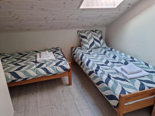 two beds sitting next to each other in a room at Pod Cisem in Kierzkowo