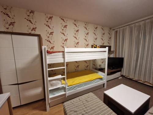 a small bedroom with a bunk bed with yellow sheets at The Nest - harmony place to spend a mountain brake in Bjelašnica