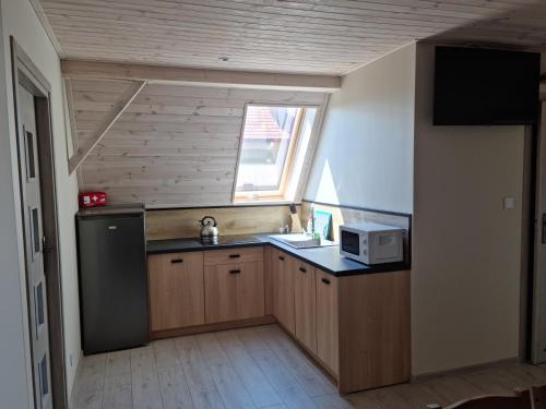 a small kitchen with a sink and a microwave at Pod Cisem in Kierzkowo