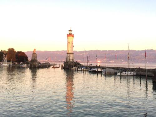 a lighthouse in the middle of a body of water at Ferienwohnung Luxus Loft - Luxuriös, exklusiv, traumhaft schön mit Aufzug in Lindau