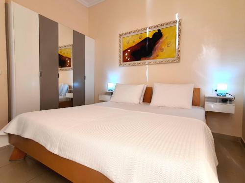 een slaapkamer met een groot wit bed met 2 kussens bij Melissa Apartments in Sarandë